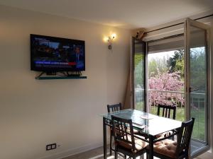 een eetkamer met een tafel en een televisie aan de muur bij Chez Lisa & Olivier 40 min Disney 15 min Paris Orly Airport in Athis-Mons