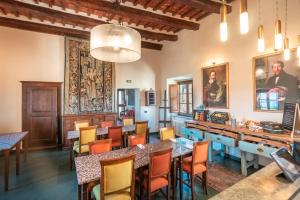 a restaurant with tables and chairs and paintings on the walls at Hotel Della Fortezza in Sorano