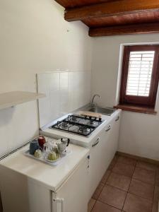 a white kitchen with a stove and a sink at Terrasini 2000 Case Vacanza in Terrasini