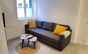 a living room with a couch and two tables at Le Palm ✧ Duplex centre historique Rouen in Rouen