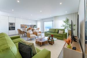 een woonkamer met groene banken en een tafel bij T3 Pelican Bay in Nazaré