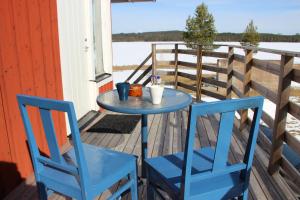 two blue chairs and a table on a porch at Lakeview Houses Sweden - Red House in Svärdsjö