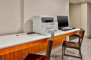 a desk with a computer and a printer on it at Holiday Inn Express Fairfax-Arlington Boulevard by IHG in Fairfax +29 photos