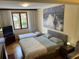 a hotel room with two beds and a tv at Apartments Leko in Portorož