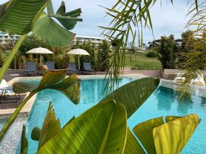 a swimming pool with green plants in front of a building at DIANA BEACH HOUSE in Albufeira