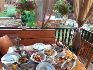 a table with plates of food on a balcony at Restaurant and Apartments - T'ga za Jug Lazaropole in Lazaropole