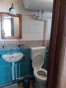 a bathroom with a sink and a toilet and a mirror at Restaurant and Apartments - T'ga za Jug Lazaropole in Lazaropole