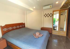 ein Schlafzimmer mit einem Bett, auf dem ein Kleid liegt in der Unterkunft CORNER VILLA - PATTAYA HOLIDAY HOUSE WALKING STREET 4 bedrooms in Pattaya South + 24 Fotos
