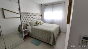 a small bedroom with a bed and a mirror at Apartamento Espelho das Águas in Florianópolis +33 photos