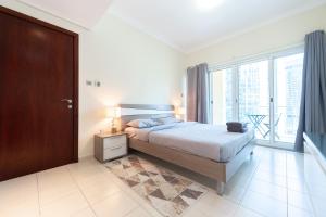 a bedroom with a bed and a large window at Elegant and spacious 1bed with 2 balconies in JLT - LAKV in Dubai