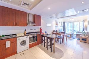 a kitchen with a washer and a table and chairs at Elegant and spacious 1bed with 2 balconies in JLT - LAKV in Dubai