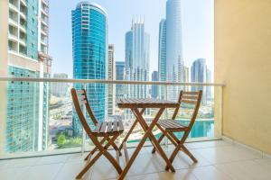 een tafel en stoelen op een balkon met uitzicht op de stad bij Elegant and spacious 1bed with 2 balconies in JLT - LAKV in Dubai