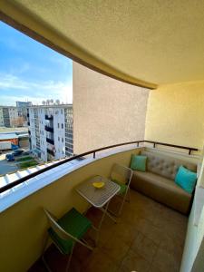 een balkon met een bank en een tafel en stoelen bij Prishtina Center Apartment in Pristina