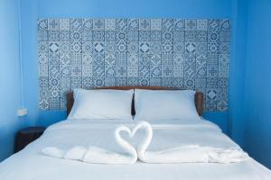 彭世洛Talavera Hostel的两只白天鹅坐在床上