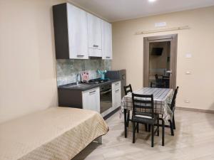eine kleine Küche mit einem Tisch und Stühlen in einem Zimmer in der Unterkunft Parsifal family room in Campofelice di Roccella