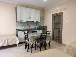 eine Küche mit einem Tisch und Stühlen im Zimmer in der Unterkunft Parsifal family room in Campofelice di Roccella