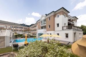 ein Hotel mit einem Pool und einem Gebäude in der Unterkunft Hotel TraumVogel in Jennersdorf