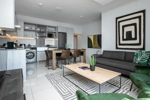 een woonkamer met een bank en een tafel bij The Median Serviced Apartment Collection in Johannesburg
