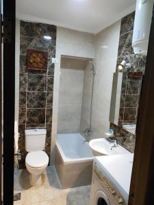 a bathroom with a toilet and a tub and a sink at شالية مميز بقرية مارينا دلتا السياحية ol2o72ool82 in ‘Izbat Abū Sulayman