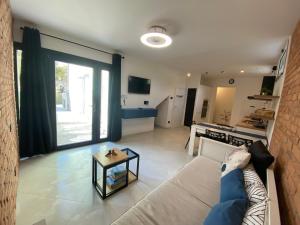 ein Wohnzimmer mit einem Sofa und einem Tisch in der Unterkunft Appartamento Anagiulia in Bardolino