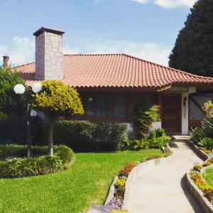 a house with a tile roof and a garden at Casa Portanova Luxe - A 1,5km da Rua Coberta in Gramado