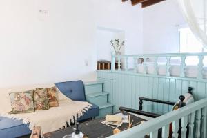 a living room with a blue couch and a table at Volcano View Nisyros in Emporeiós +36 photos