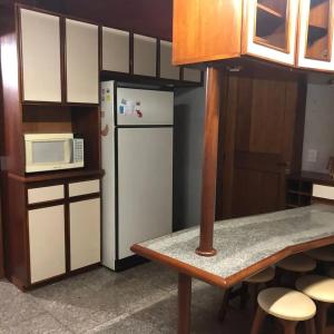 a kitchen with a white refrigerator and a microwave at Casa Portanova Luxe - A 1,5km da Rua Coberta in Gramado
