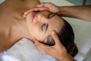 Un uomo che si fa fare un massaggio facciale in una spa di Acquaghiaccia Spa & Country House a Vagli