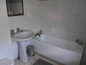 a white bathroom with a sink and a bath tub at La maison du Mas Rando in Saint-Georges-Nigremont
