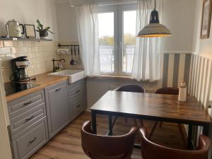 een keuken met een tafel en stoelen en een wastafel bij Relitto Boutique und Aparthotel Borkum in Borkum