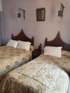 twee bedden naast elkaar in een slaapkamer bij HOTEL DU LOUVRE in Casablanca