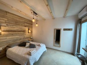 オルビアにあるIknos Guest Houseの木のアクセントの壁とベッドが備わるベッドルーム1室が備わります。
