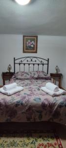 sypialnia z dużym łóżkiem z dwoma stołami w obiekcie CASA DE LOS ABUELOS w mieście Ortigosa del Monte