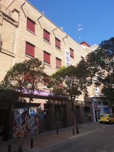 un edificio con un coche amarillo aparcado delante de él en Hostal 4C Cuatro Caminos, en Madrid