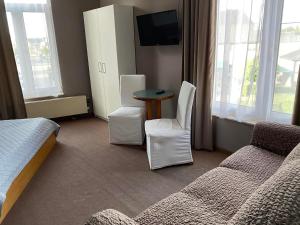 ein Hotelzimmer mit einem Bett, einem Tisch und Stühlen in der Unterkunft Hotel Hooghuys in Hamont