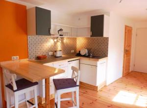 a kitchen with a wooden table and a counter top at Biohof Buschmühle in Königsfeld