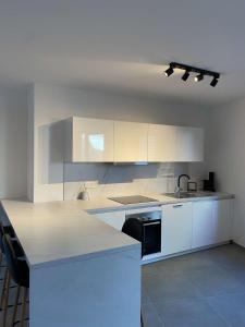 una cucina con armadi bianchi e piano di lavoro di New appartement centre de Spa avec parking privé a Spa
