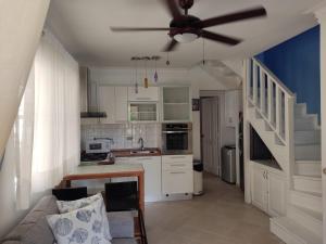 a kitchen with a couch and a ceiling fan at Las Palmeras RIKI R in Boca Chica