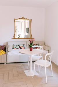 a room with a table and a couch with a mirror at Casa Cavour Garda in Garda