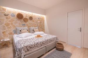 a bedroom with a bed and a stone wall at Ekati Mare Boutique Resort in Kavos