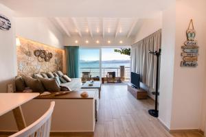 uma sala de estar com um sofá e uma televisão em Ekati Mare Boutique Resort em Kavos