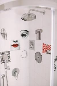 a bathroom with a shower with stickers on the wall at Casa Cavour Garda in Garda +88 photos