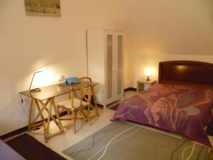 a bedroom with a bed and a desk and a table at La Gilberdiere in La Rochelle-Normande