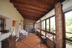 Casa Rural Casa Manuel في Moya: غرفة معيشة كبيرة مع جدار من الطوب ونوافذ