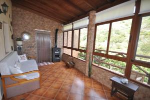 uma sala de estar com janelas grandes e um sofá em Casa Rural Casa Manuel em Moya