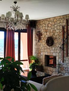 uma sala de estar com um sofá e uma lareira de pedra em Vytina Mountain View Hotel em Vytina