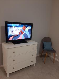 a flat screen tv sitting on a dresser at Apartament Zamkowy in Malbork
