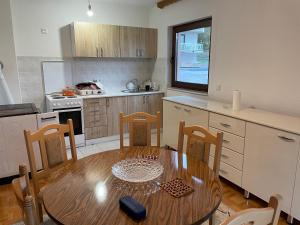 a kitchen with a wooden table and a table and chairs at Porodicna kuca za odmor Kovaci in Zavidovići