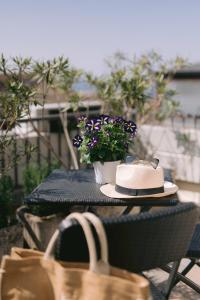 een hoed en een tas op een tafel met een plant bij Casa Cavour in Garda