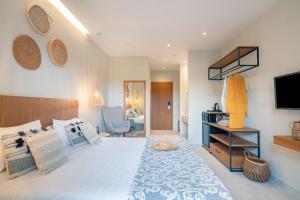 sypialnia z dużym łóżkiem z telewizorem na ścianie w obiekcie Ekati Mare Boutique Resort w mieście Kavos